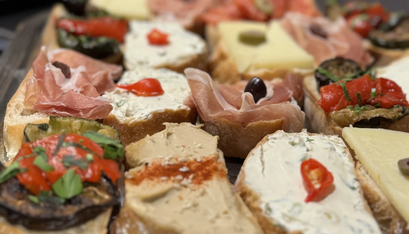 Belegte Canapés mit Parmaschinken, Frischkäse, Paprika und Oliven aus der Nähe