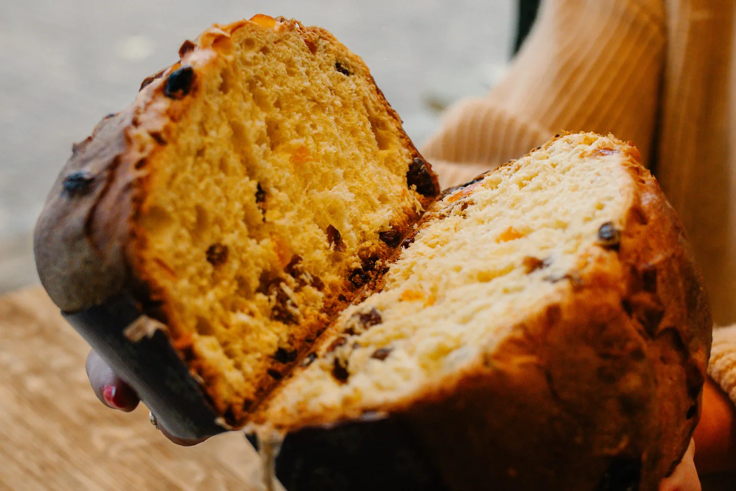 Ein aufgeschnittener Panettone Classico mit Rosinen und kandierten Früchten, in zwei Hälften gehalten